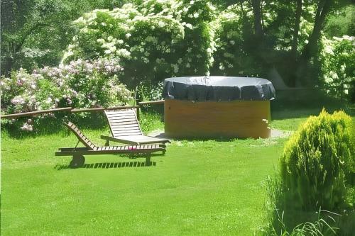 two chairs sitting in the grass next to a hot tub at Warm apartment in Ardanué with mountain view, 45 m² in Ardanué