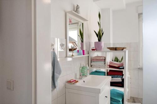 a white bathroom with a sink and a mirror at Familienfreundliche Ferienwohnung in Kenz