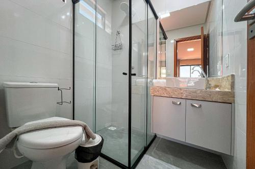 a bathroom with a toilet and a glass shower at Bessa Apto Novinho 200m Praia 2 Quartos 5 Pessoas in Nossa Senhora do Livramento