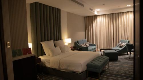 a hotel room with a bed and chairs at فندق سدو بوتيك Hotel SDU BOUTIQUE in Jazan
