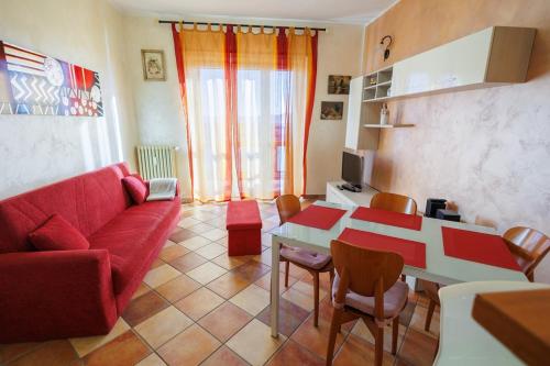 a living room with a red couch and a table at Casa Naty Bilocale a Collegno-Corso Francia in Collegno