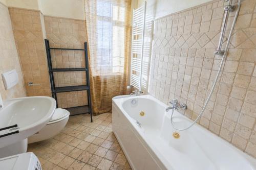 a bathroom with a tub and a toilet and a sink at Casa Naty Bilocale a Collegno-Corso Francia in Collegno