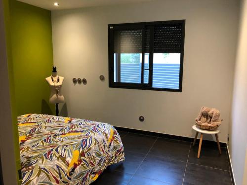 une chambre avec un lit, une fenêtre et une chaise dans l'établissement Villa des mazes, à Vallon-Pont-dʼArc