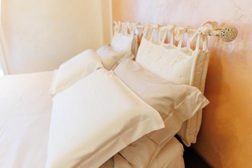 a bed with white sheets hanging on a wall at Casa Naty Bilocale a Collegno-Corso Francia in Collegno