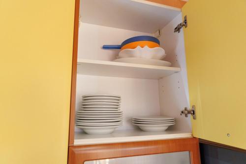 a pantry with plates and bowls on shelves at Casa Naty Bilocale a Collegno-Corso Francia in Collegno