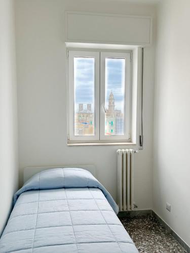 a bedroom with a bed and a window at Isabel apulian apartment in Molfetta