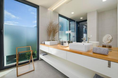 a bathroom with two sinks and a large window at Aljube Residences Duplex in Ponta Delgada