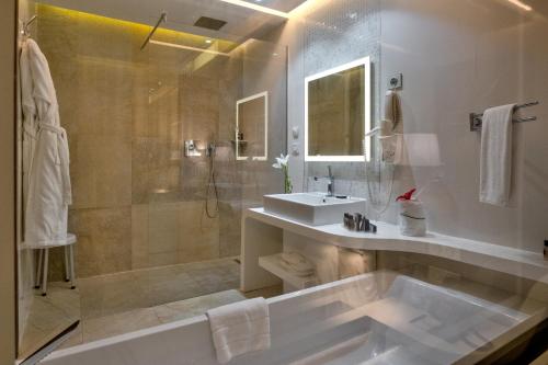 a bathroom with a tub and a sink and a shower at La Cigale Tabarka in Tabarka