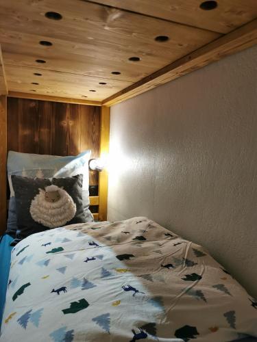 une chambre avec un lit et un plafond en bois dans l'établissement le Nid Douillet au pied de Megève, à Demi-Quartier