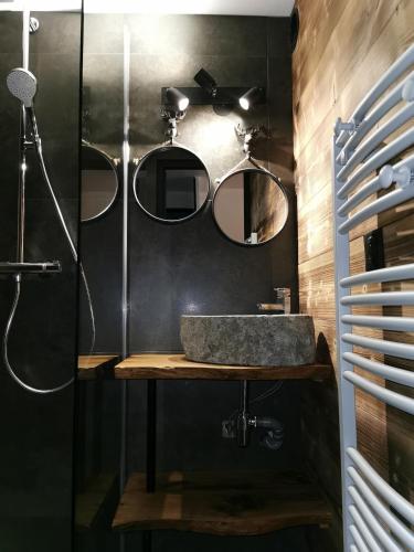 une salle de bain avec un lavabo et deux miroirs dans l'établissement le Nid Douillet au pied de Megève, à Demi-Quartier