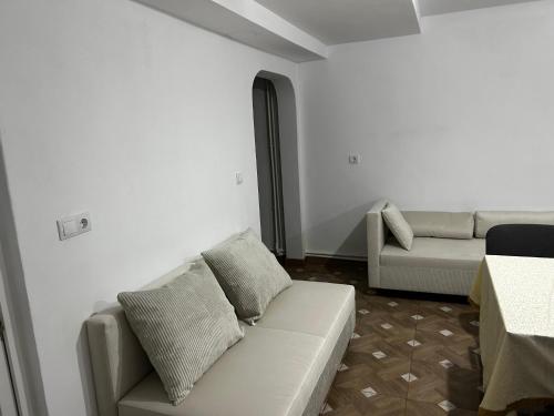 a white living room with a couch and a table at Insieme in Vidra