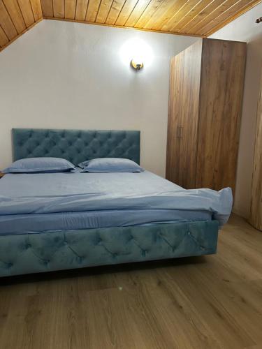 a bedroom with a blue bed with a wooden floor at Insieme in Vidra