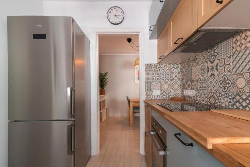a kitchen with a stainless steel refrigerator and a table at Casa Galicia in El Médano