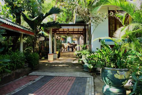 a courtyard of a building with trees and plants at Green Land Guest House in Pinnawala