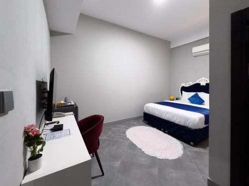 a bedroom with a bed and a desk with a computer at Euro Homes Hotel in Accra