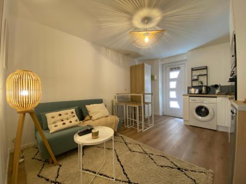 un salon avec un canapé vert et une table dans l'établissement Le Suchet, BNBconciergerie, à Lyon