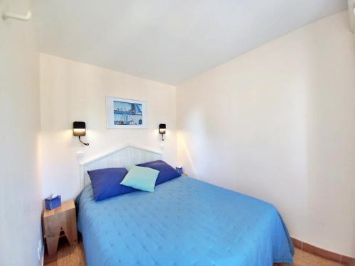 une chambre avec un lit bleu dans une pièce blanche dans l'établissement Le DRAMONT Appartement vue panoramique MER LAC FORET, à Saint-Raphaël