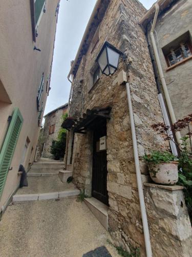 un ancien bâtiment en pierre avec une porte et une lampe dans l'établissement Charmant Appartement au Broc, à Le Broc
