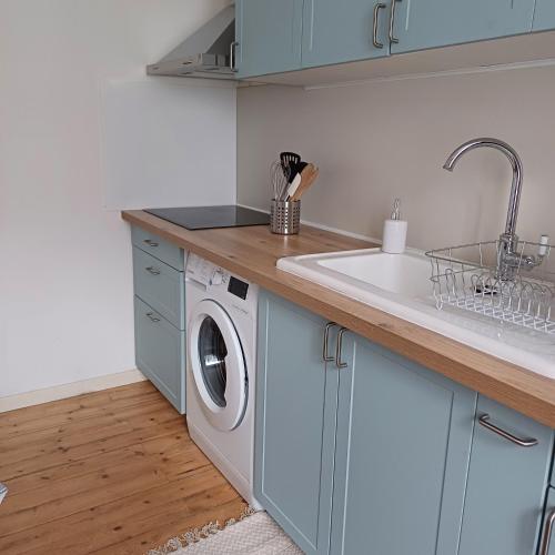 une cuisine avec un évier et une machine à laver dans l'établissement L'Epicerie Maison années 30, à Caen