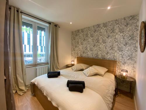 - une chambre avec un lit et 2 serviettes noires dans l'établissement Le Suchet, BNBconciergerie, à Lyon