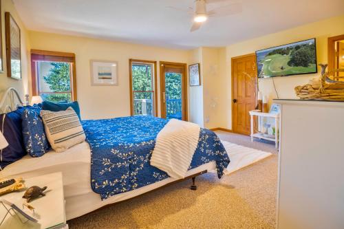 a bedroom with a bed with a blue and white comforter at Waterfront luxury w-beach resort-pool-golf-tennis-fishing & views! in Nags Head