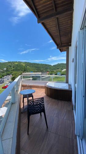 a patio with a table and a bench on a balcony at Reserva Praia Hotel in Balneário Camboriú