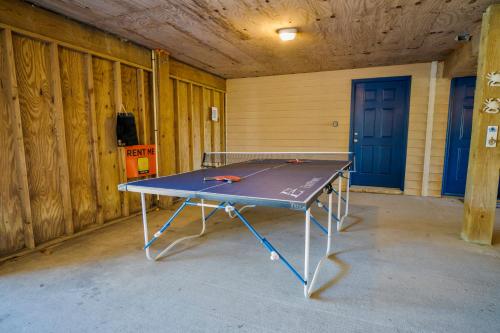 a ping pong table sitting inside of a room at Waterfront luxury w-beach resort-pool-golf-tennis-fishing & views! in Nags Head