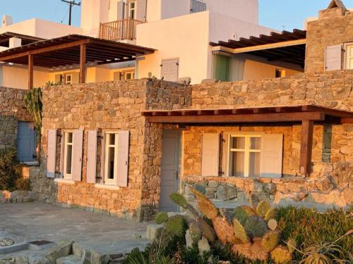 a stone house with a stone wall at White Rock Suites & Villas in Houlakia