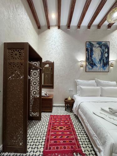 a bedroom with a bed and a red rug at Riad Safia in Rabat