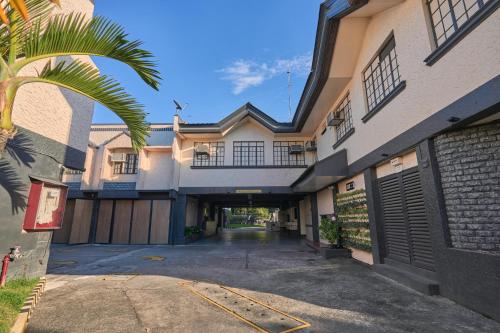 an alleyway between two buildings with a palm tree at Victoria Court San Fernando in San Fernando