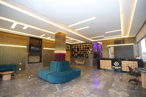 a lobby with a blue chair and wine bottles at Sahara Beach in Tan-Tan Plage