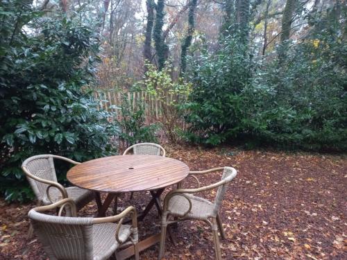 a wooden table and two chairs sitting next to a table at chalet bosrust nr 38 in Lanaken
