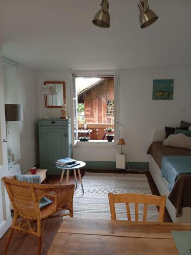 a bedroom with a bed and a table and a window at Studio Le rêve de Rive in Nyon