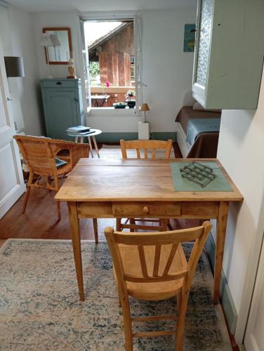 a dining room with a wooden table and chairs at Studio Le rêve de Rive in Nyon