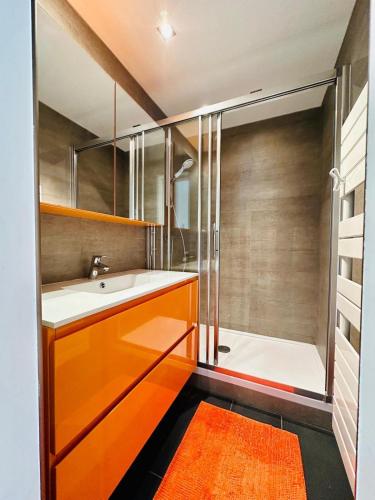 La salle de bains est pourvue d'un lavabo orange et d'une douche. dans l'établissement Appartement 6 pers - Port privée - Plage privée - Piscines - Tennis, à Bandol