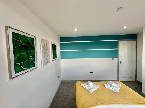 a bedroom with a yellow bed and green and white stripes at Two Bedroom Flat by Brookland Stays Serviced Accommodation Short Lets Leeds with Free WiFi in Leeds