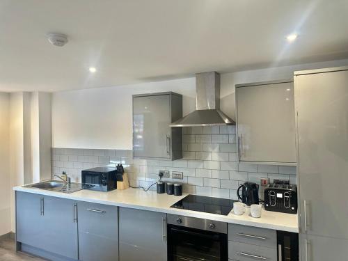 a kitchen with a sink and a counter top at Two Bedroom Flat by Brookland Stays Serviced Accommodation Short Lets Leeds with Free WiFi in Leeds