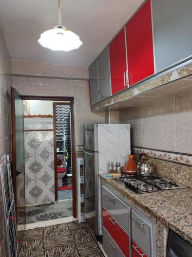 a kitchen with red cabinets and a stove top oven at Charming Moroccan apartment in Casablanca