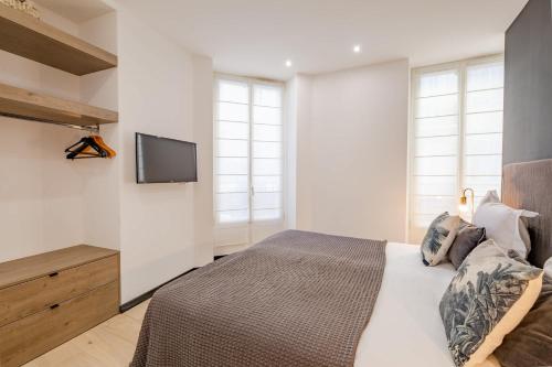une chambre avec un lit et une télévision sur un mur dans l'établissement Scandinavian Urban 1 - 2BR apartment in center close to Palais des Festivals and the beach, à Cannes