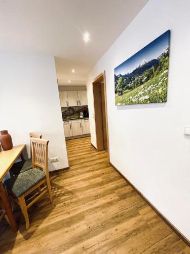 a living room with a table and a painting on a wall at Gästehaus Achental in Berchtesgaden