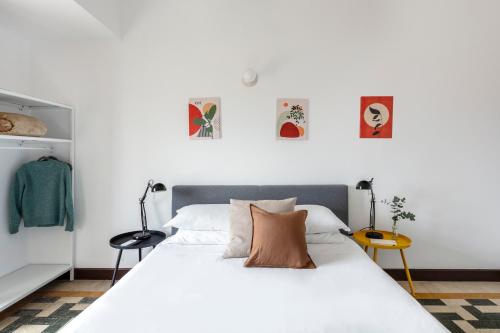 a bedroom with a large white bed with two lamps at Casa Vespi by Hili in Rome