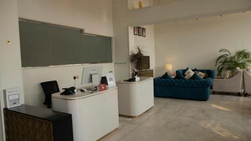 a meeting room with a large screen and a blue couch at فندق سدو بوتيك Hotel SDU BOUTIQUE in Jazan