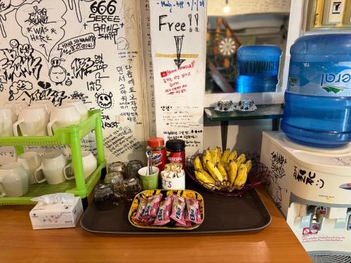 a counter with a tray of food and a bowl of bananas at Aloha LuangPrabang Hostel Capsule in Luang Prabang