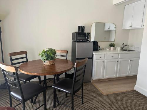 a kitchen with a table and chairs and a kitchen with a refrigerator at The Alcalde Hotel in Gonzales