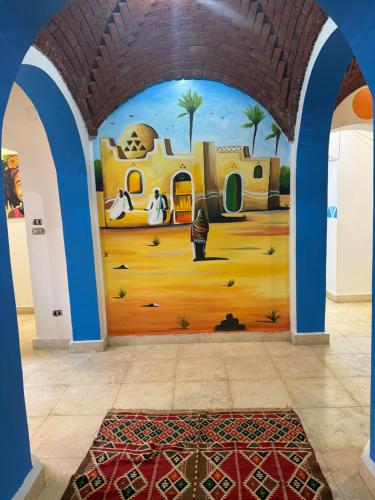 a room with a mural of a house at king kassem nubian guest house in Aswan