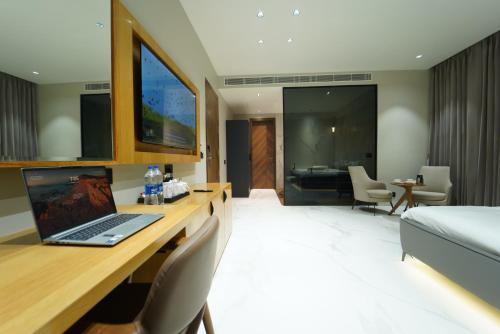 a hotel room with a desk with a laptop on it at Hotel Millennium in Hisār