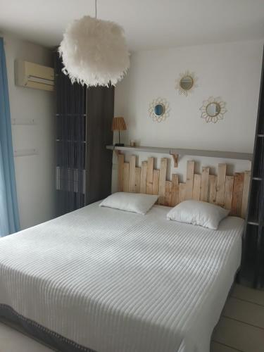 Cette chambre comprend un lit avec des draps blancs et deux miroirs. dans l'établissement T3 duplex malibu village pass piscine en supplément 2 a 8 personnes, à Canet
