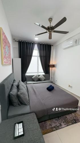 a bedroom with a bed and a couch and a ceiling fan at The Ambiance, Melaka in Melaka