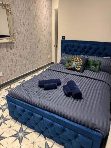 a large blue bed with two blue pillows on it at Gloucester - Apartment - Sleeps 2 - Parking - 97WS in Gloucester