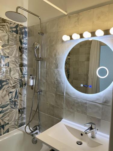 a bathroom with a sink and a shower with a mirror at Ambassadeur Hotel - Cherbourg Port de Plaisance in Cherbourg en Cotentin